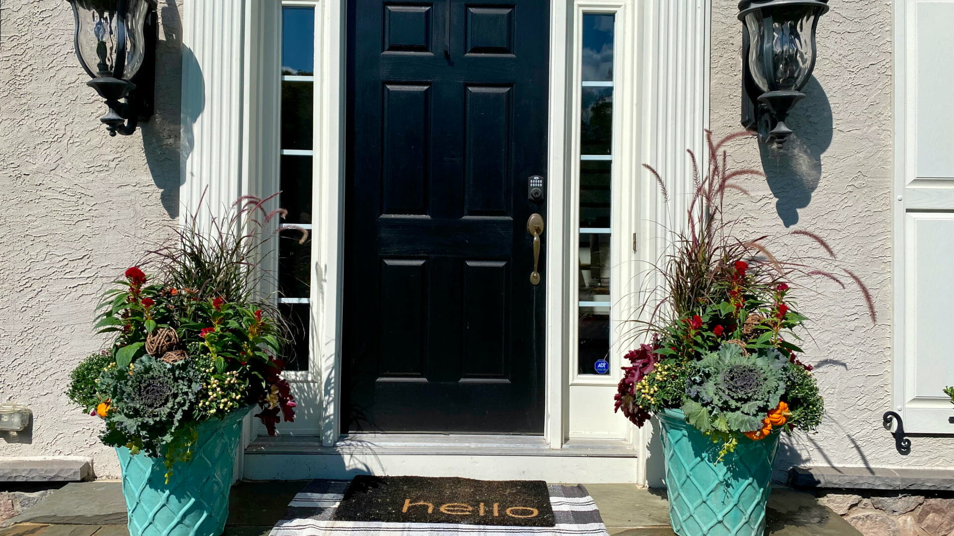 Front door and two giant urns with pretty plants for autumn